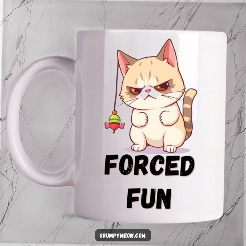 Funny mug showing a grumpy cat disdainfully batting at a dangling toy, capturing relatable feline boredom and playful annoyance.