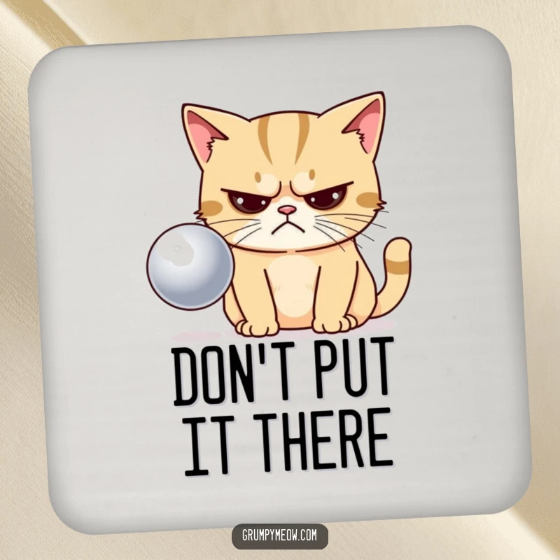 Funny drink coaster with a grumpy cat narrowing its eyes, staring disapprovingly at a shiny ball, for table protection.