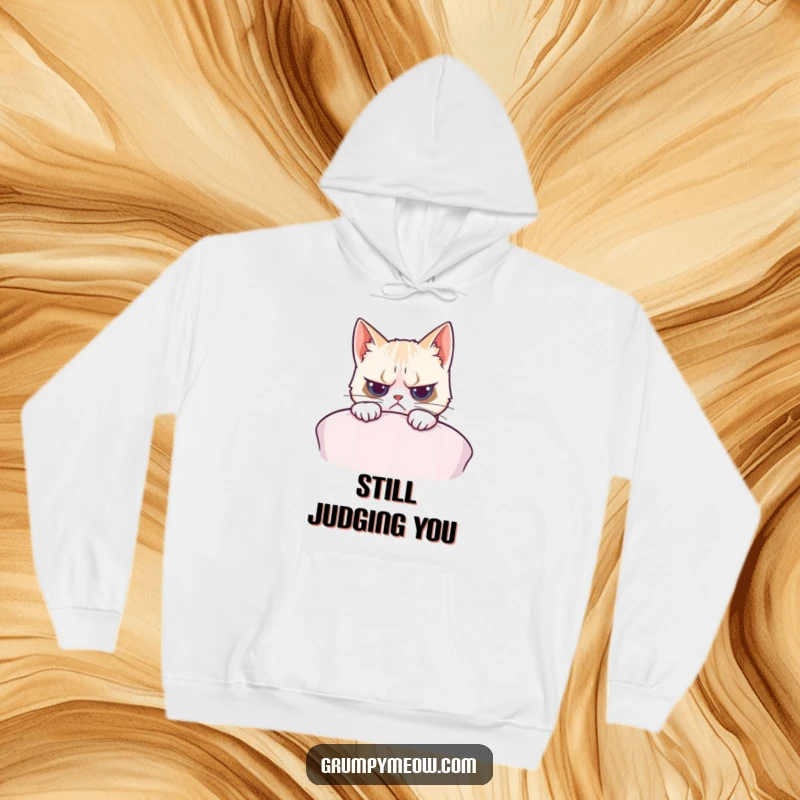 Funny hoodie featuring a grumpy cat peeking with subtle interest over a soft cushion, perfect for cozy, humorous lounging.