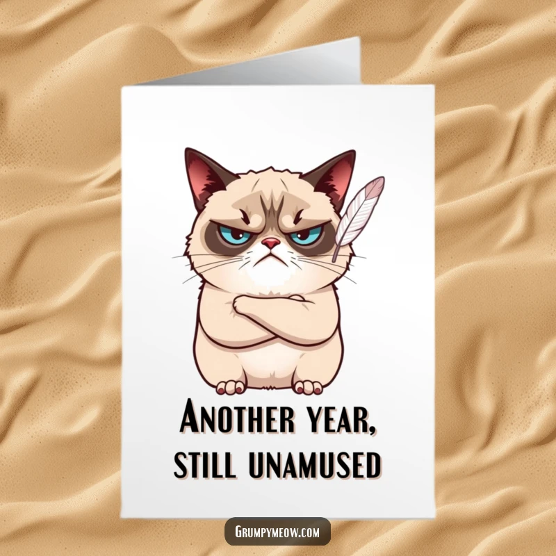 Funny Free Printable Birthday Card: Grumpy cat with crossed arms looks unimpressed by a floating feather on a birthday.