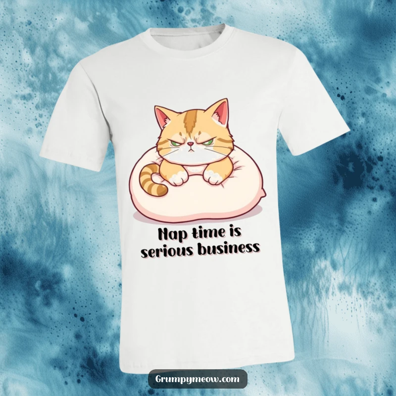 Funny T-Shirt: A scowling cat attempts to nap on a plush pillow, ear twitching, radiating sleepy, grumpy vibes.